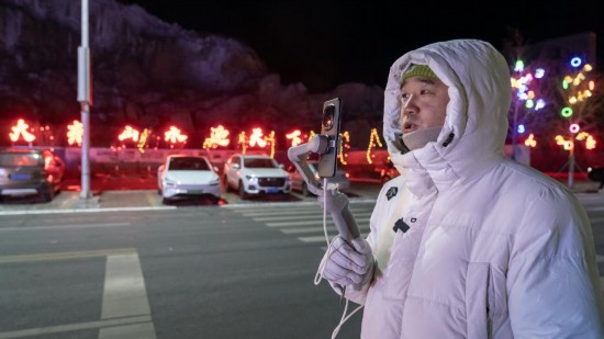 在吉林市阿什哈達(dá)霧凇觀景帶，霧凇播報(bào)員正在直播。新華社記者 李典 攝