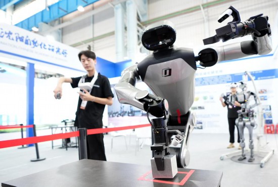 9月5日，在沈陽(yáng)的2025全球工業(yè)互聯(lián)網(wǎng)大會(huì)的展覽區(qū)現(xiàn)場(chǎng)，中國(guó)科學(xué)院沈陽(yáng)自動(dòng)化研究所的機(jī)器人工程師在調(diào)試具身智能操作系統(tǒng)。新華社記者 李鋼 攝