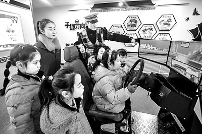 山東省榮成市公安局道路交通安全宣傳教育基地，交警帶領(lǐng)小學(xué)生現(xiàn)場體驗?zāi)M駕駛。新華社發(fā)